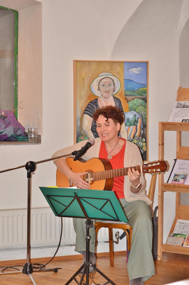 Veronika singt mit Gitarre bei einem Liederabend
